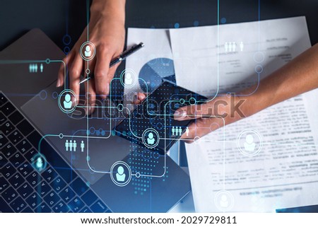 Hands of woman hr specialist is typing the keyboard in the internet to find the best candidates to create international network in recruitment process. Casual wear. Social media hologram icons.