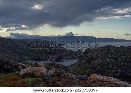 Horizontal image of Creus Cape coast in a cloudy day with sunrays through the clouds