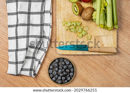 top view picture of fruits and vegetables to make detox juice with knife and kitchen towel