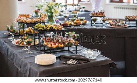 Banquet table with snacks, food on plates, festive table, corporate food Royalty-Free Stock Photo #2029767140