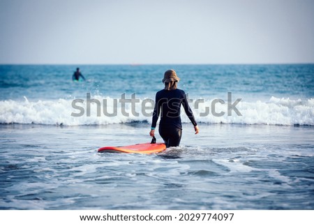Surfer woman practice surfing in the white water