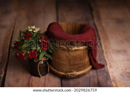 Newborn Backdrops Photo for Girls. Vintage bucket with flowers on a wooden background.	