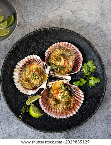 Oven baked scallops on the shell with parsley, lemon, olive oil and french bread crumbs Royalty-Free Stock Photo #2029835129