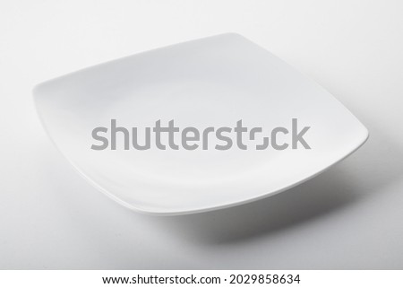 A white square curved plate in minimalist style on white background