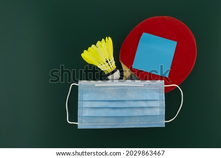 Table tennis racket and shuttlecock cover with a medical face mask. Sports during the quarantine period concept with free copy space