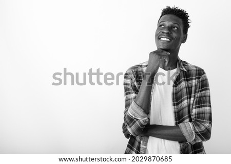 Studio shot of young handsome African hipster man with afro hair against white background in black and white