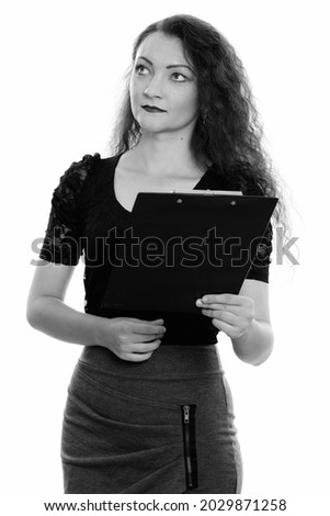 Studio shot of beautiful businesswoman with curly hair isolated against white background in black and white