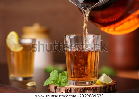 Lime tea , pouring black tea Chai traditional beverage with lemon spices Kerala India. Two glass of organic ayurvedic or herbal drink India, green tea good in winter for immunity boosting. Royalty-Free Stock Photo #2029889525