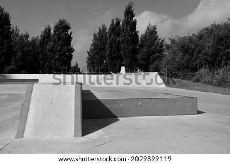 A beautiful sunny skatepark in black and white.