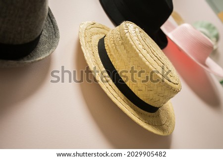 A selective of hats hanging on a pink wall