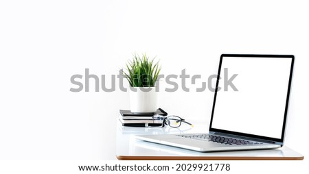 Mockup blank white screen laptop computer and houseplant on white top table with copy space. Royalty-Free Stock Photo #2029921778