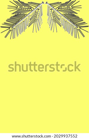 Two spruce twigs folded from nails on a yellow background. construction christmas concept.