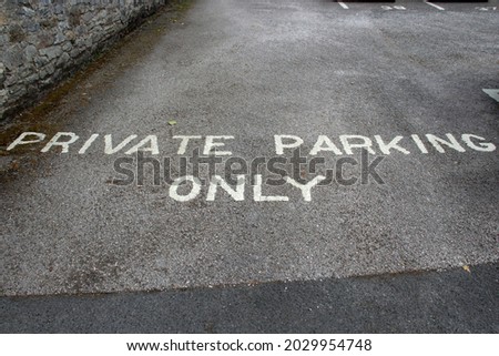 Private parking only written in white paint on a grey tarmac car park