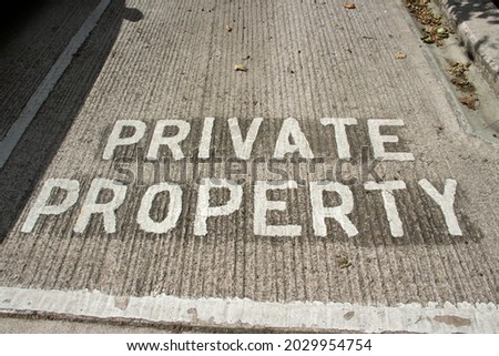 Private Property written in white paint on a grey cement parking space