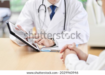 Hands of a male doctor explaining to the elderly Royalty-Free Stock Photo #2029960946
