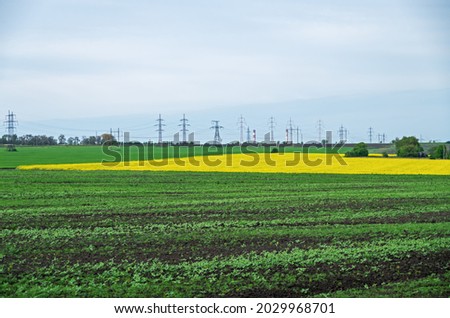 High-voltage power line crosses a spring field in the evening before sunset