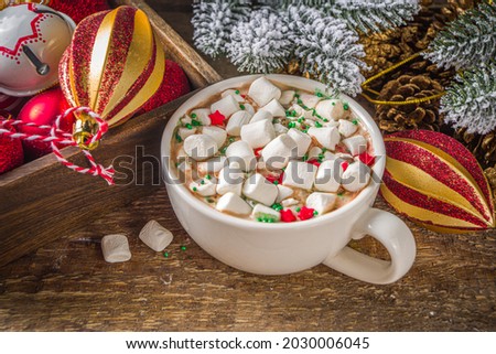 Hot chocolate with marshmallows, warm chocolate drink for Christmas morning breakfast, on wooden background with Christmas decorations, cozy winter pic copy space