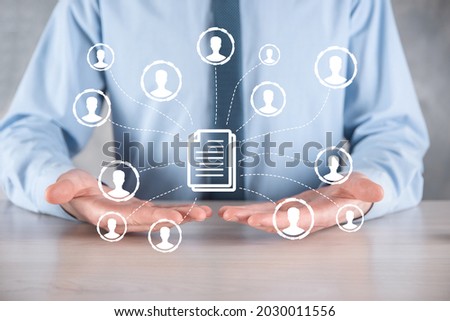 Man hold document and user icon.Corporate data management system DMS and document management system concept. Businessman click or publish on document connected with corporate users.