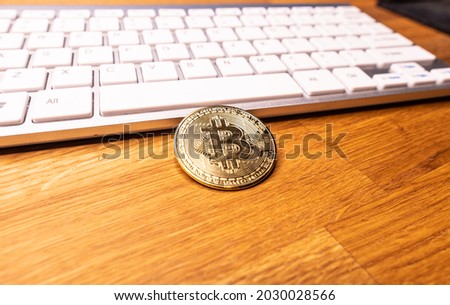 Bitcoin cryptocurrency coin on the background of the computer keyboard