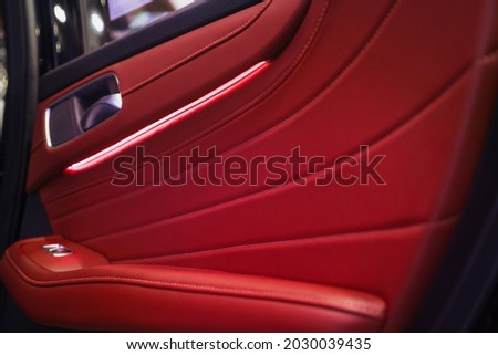Luxurious car doors covered with red leather with LED lights.