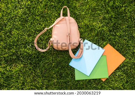 school backpack, backpack with books of lying on the grass