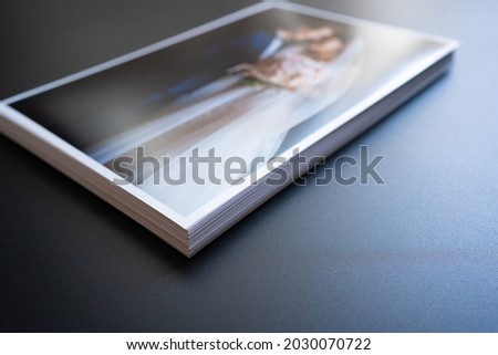 stack of a printed copy of the wedding photos. the result of the photographer's work at the wedding. printed products. a photo session of the bride and groom.