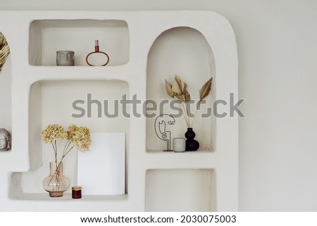 Room interior with wall design, decor at niche shelf. Modern home decoration, indoors apartment style in white. Vintage archs, exotic space of living room. Natural decorative elements. Royalty-Free Stock Photo #2030075003