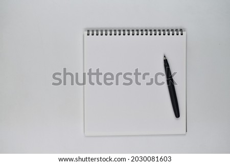 Flat lay photo, blank sheet of blank note and pen on white background