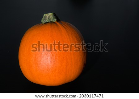 Bright orange pumpkin on Halloween on a black background.