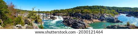 Jagged rocks and the dangerous white waters of the Potomac River at the Great Falls Park in, Virginia. Panoramic view Royalty-Free Stock Photo #2030121464