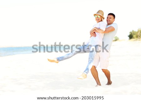 A picture of a young romantic couple having fun at the beach