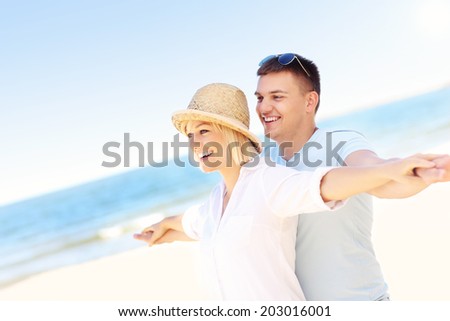 A picture of a young romantic couple hugging at the beach