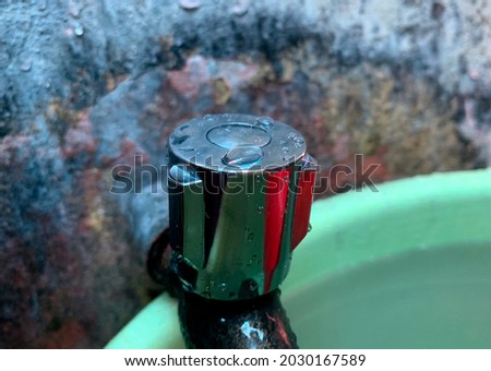 rusty old bathroom wall with green bucket