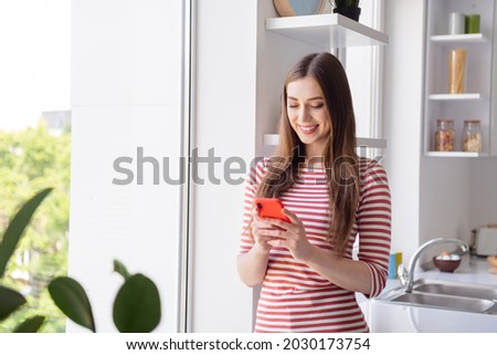 Photo of pretty young nice woman good mood hold phone rest relax smile weekend indoors inside kitchen