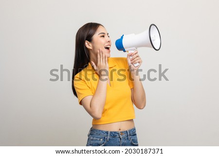Shout out loud with megaphone. Young beautiful asian woman woman announces with a voice about promotions and advertisements for products at a discounted price. Shopping and fashion concept. Royalty-Free Stock Photo #2030187371