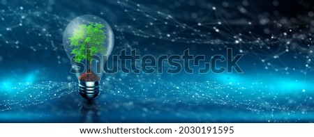 Tree growing on lightbulb with digital convergence and blue network technology background. Environmental Technology, Green Technology, Green Computer, IT ethics, Csr, and Free IT Concept.