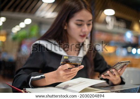 Beautiful Asian women holding credit card and mobile phone for shopping online.she smiling and happy 
