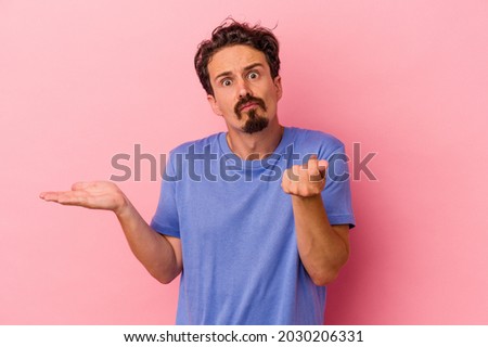 Young caucasian man isolated on pink background showing that she has no money.