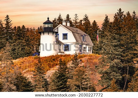 Bear Island Lighthouse in Maine,  against a golden orange sky
