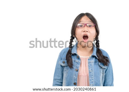 Portrait of surprised cute little asian girl child standing isolated over white background. Looking at camera and open mouth, emotion face concept