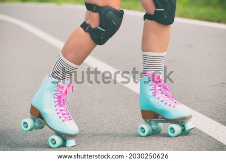 Woman rollerskater wearing knee protector pads on her leg