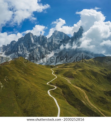 Hiking path from Passo Rolle to Baita Segantini with Pale di San Martino mountains in background. Aerial view Royalty-Free Stock Photo #2030252816