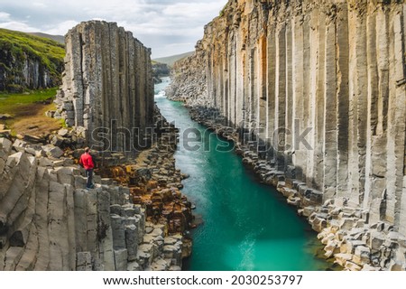 Man hiker in red jacket visit Studlagil basalt canyon, with rare volcanic basalt column formations, Iceland Royalty-Free Stock Photo #2030253797