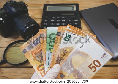 laptop, calculator, digital camera and money, store selling photographic equipment, pawnshop concept, closeup