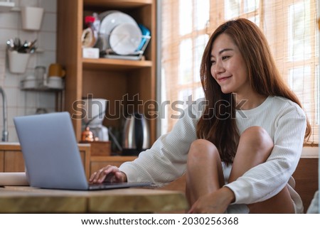 A beautiful young asian woman freelancer using laptop computer for working online at home