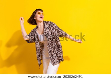 Photo of funky millennial funny lady dance look empty space wear eyewear leopard shirt isolated on yellow color background