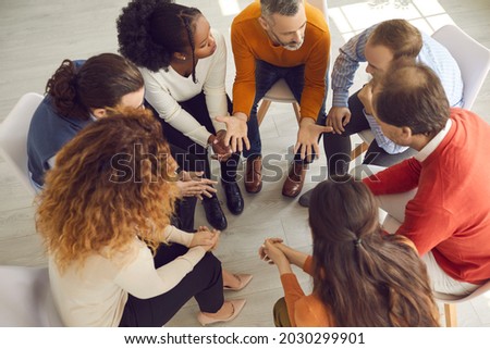 Professional therapist meeting with multiracial group therapy patients. Diverse people supporting each other and talking about their issues and ways to solve problems. View from above, high angle shot