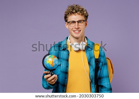 Young fun boy teen student in casual clothes backpack headphones glasses hold in hand Earth world globe isolated on plain violet background studio Education in high school university college concept Royalty-Free Stock Photo #2030303750
