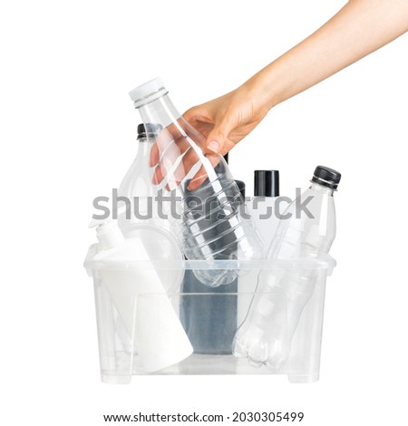 Female hand putting plastic bottle into special container foor recycling on whte isolated background