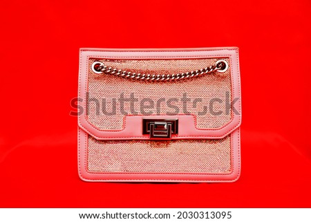 a handbag kept against a plain red background